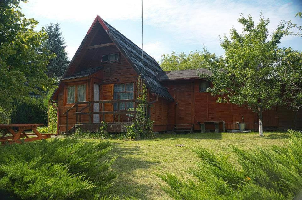 a wooden house with a picnic table in front of it at Tleniowo in Tleń