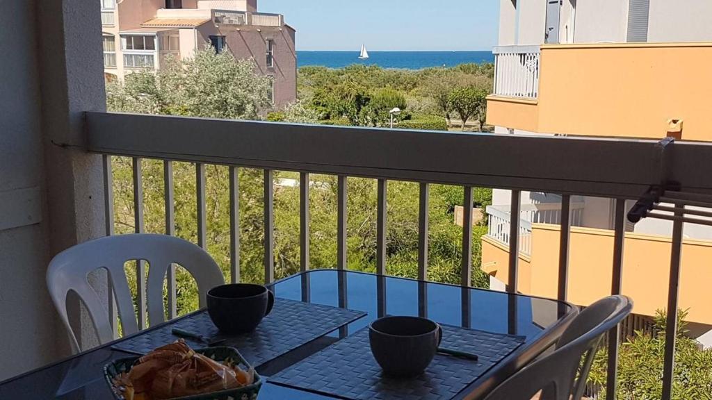 - une table sur un balcon avec vue sur l'océan dans l'établissement Accès direct plage pour ce superbe T2 moderne et fonctionnel - 6FR325, à Saint Cyprien Plage