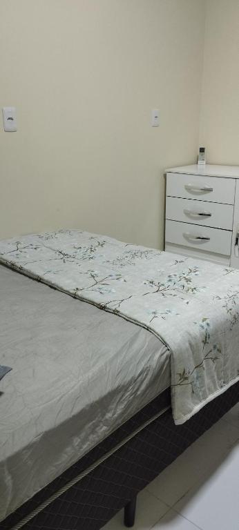 ein Schlafzimmer mit einem Bett und einer Kommode in einem Zimmer in der Unterkunft Apartamento em Penha in Penha