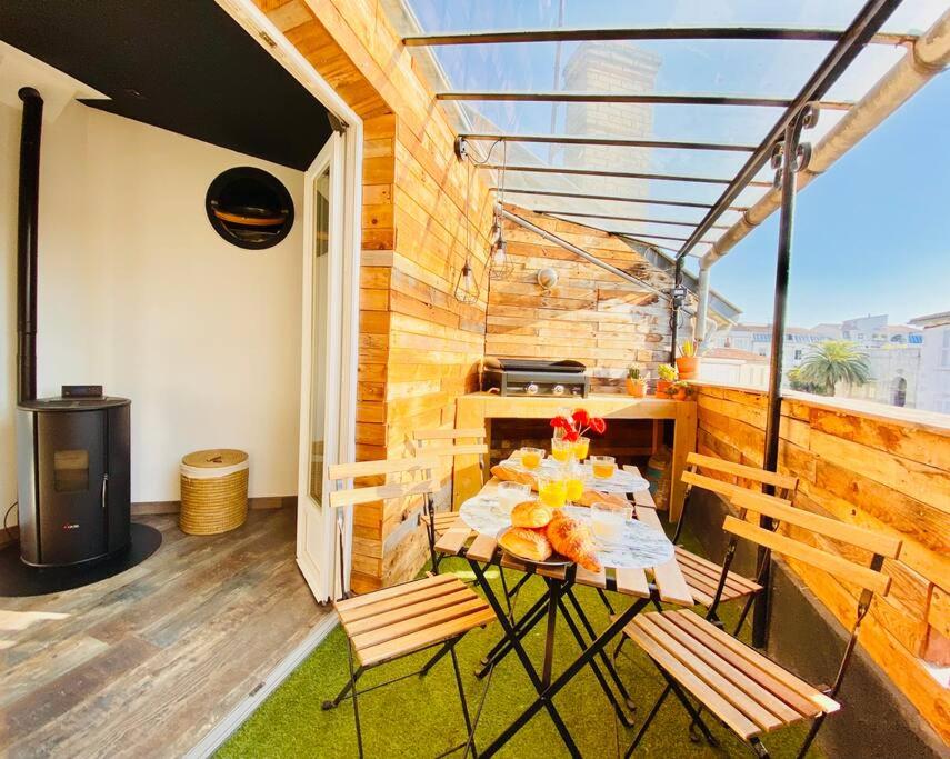 un patio avec une table et des chaises sur un balcon dans l'établissement La Rochelle Royale - Ville, à La Rochelle