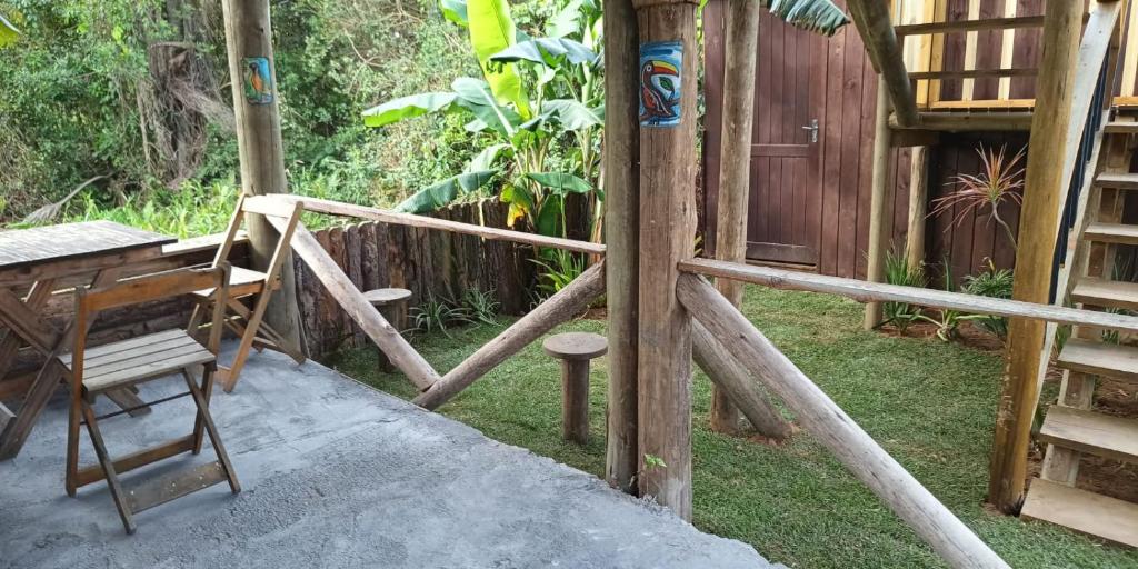 a wooden house with a ladder and a chair at Cabanas Sudarê na Praia do Rosa in Imbituba