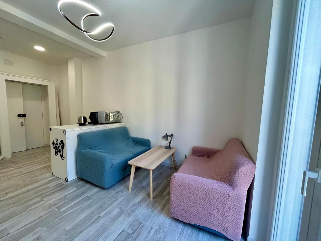 a living room with two chairs and a table at Prospettiva Medina in Naples