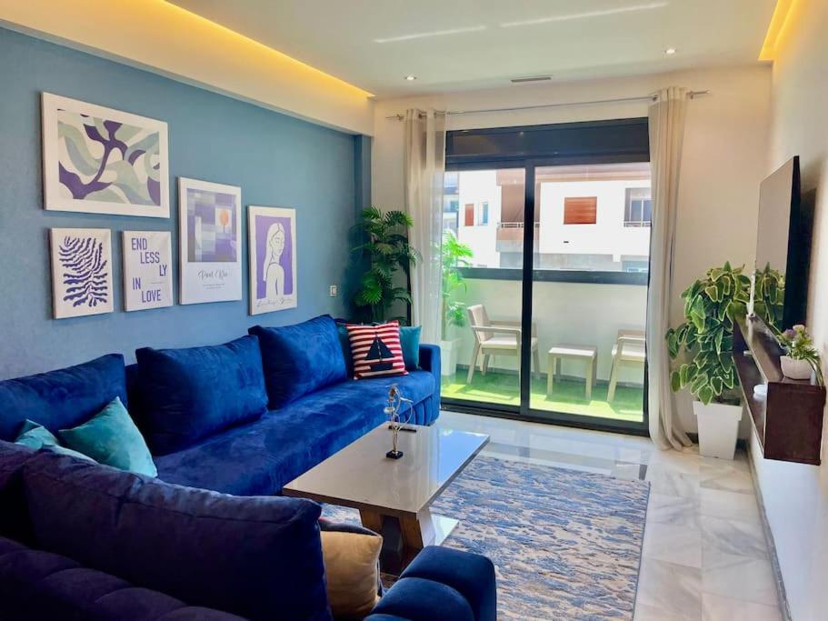 a living room with a blue couch and a table at The Sapphire Suite - 2 BR Near Beach & TGV Station in Tangier
