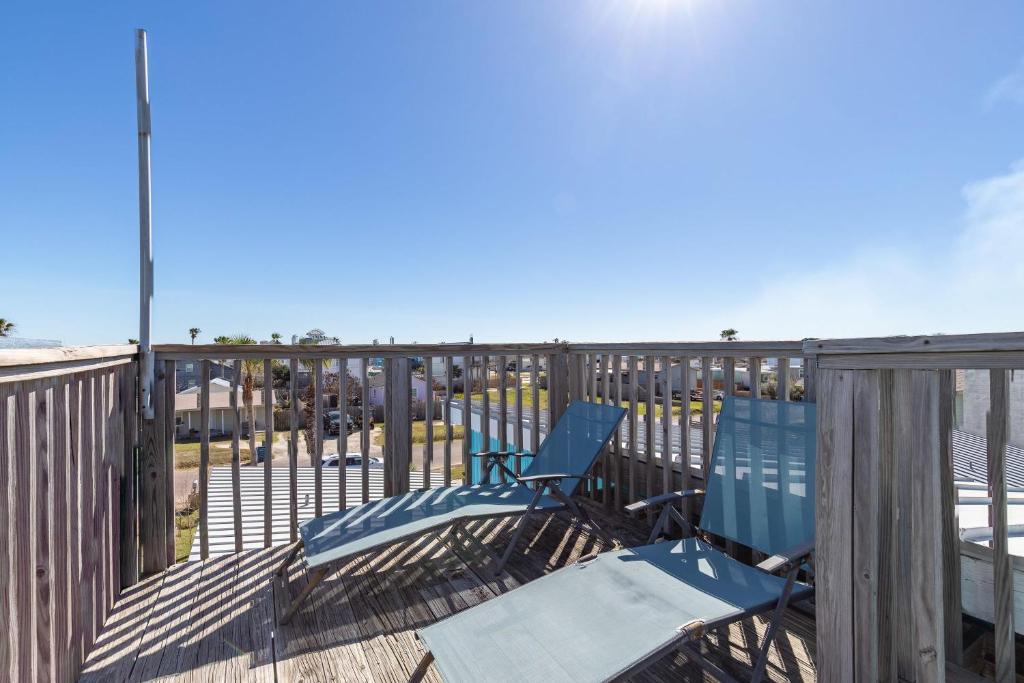 2 sillas azules sentadas en una terraza con vistas a la playa en Blue Ivy, en Port Aransas