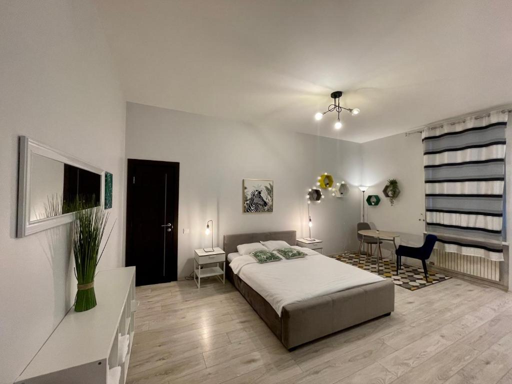 een slaapkamer met een bed, een tafel en een bureau bij Studio Elizabete 3 in Rīga