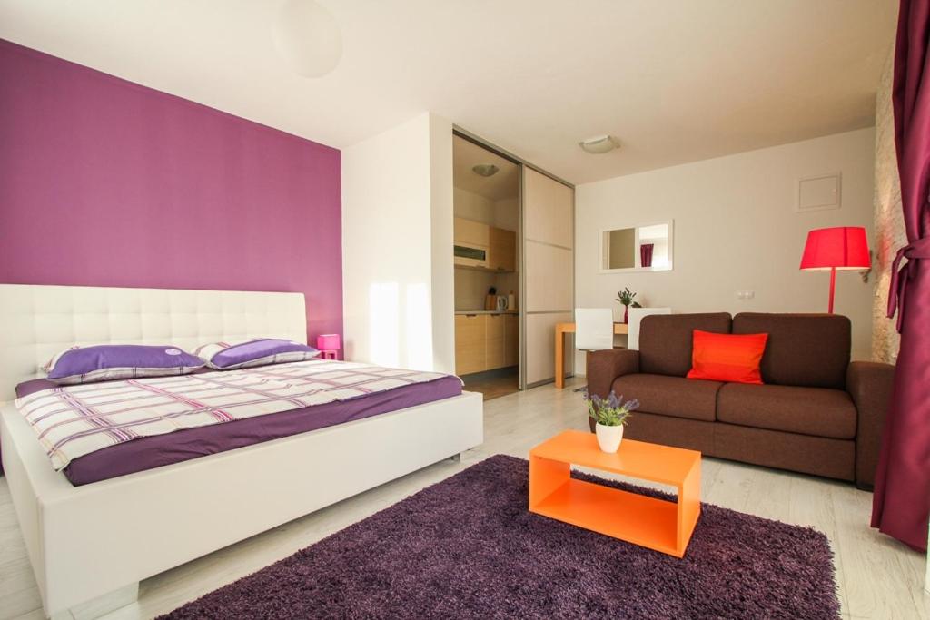 a bedroom with a large bed and a couch at Apartment Gloria in Trogir