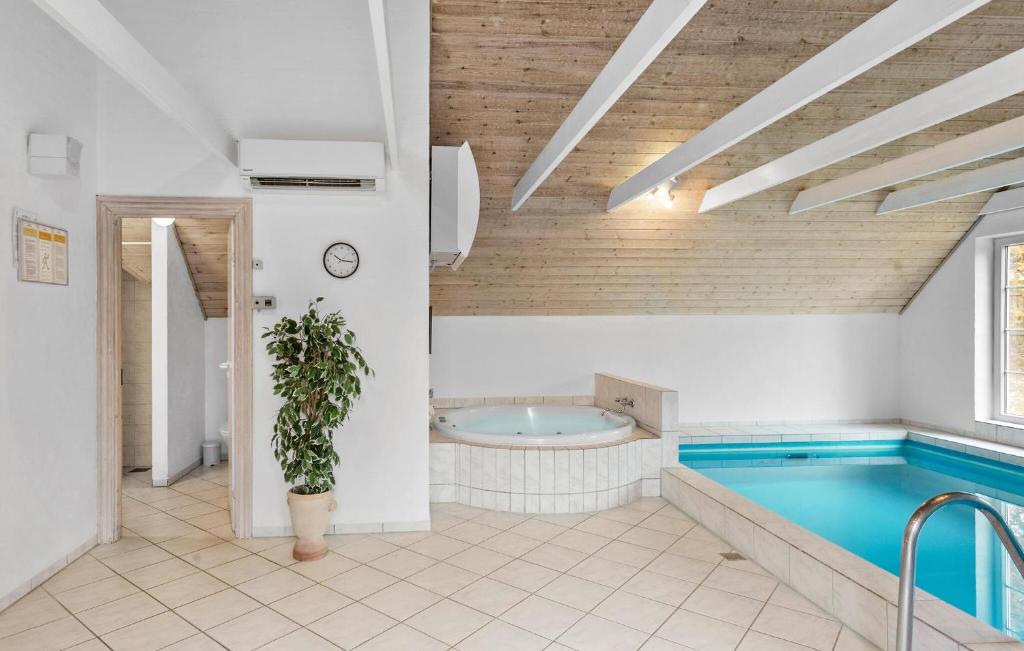 a large bathroom with a swimming pool and a tub at Nice Home In Væggerløse With Sauna in Marielyst