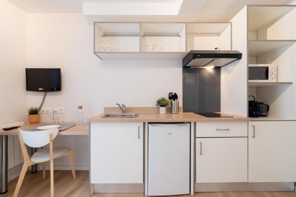 une cuisine avec des armoires blanches et un comptoir en bois dans l'établissement Fully-equipped studio next to Lille Flandres, à Lille