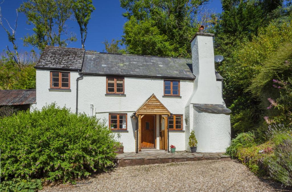 an old white house with a wooden door at Hedgehog Cottage Wheddon Cross in Wheddon Cross