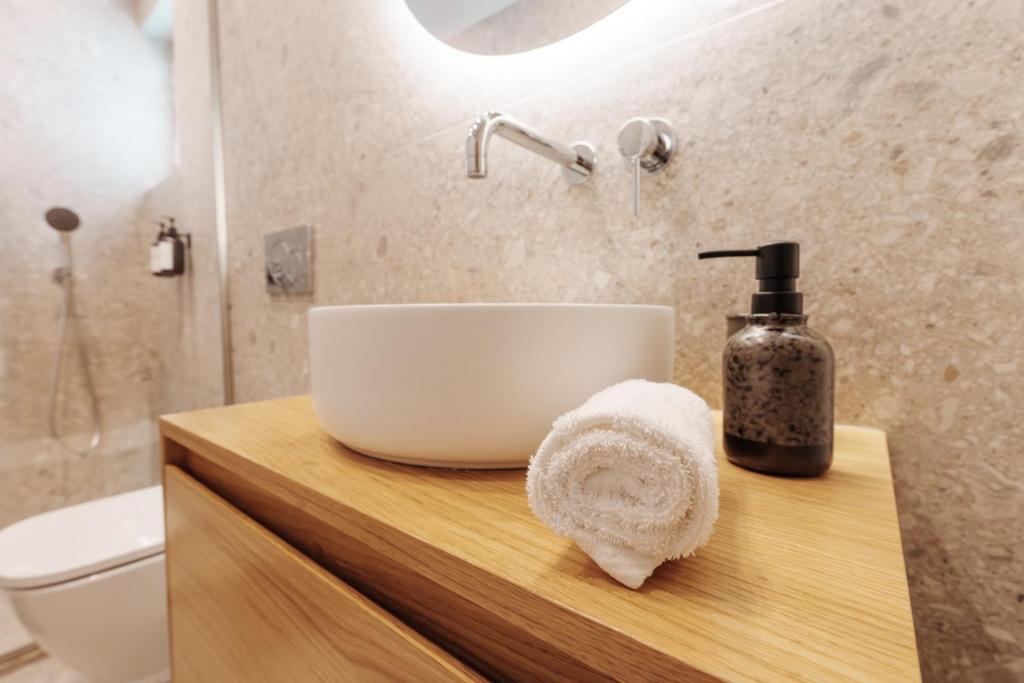 a bathroom with a sink and a bottle of soap at Libyan Sea Suites in Ierápetra