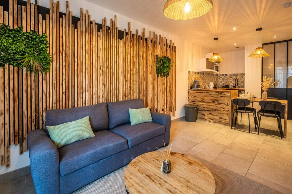 un salon avec un canapé bleu et une table dans l'établissement OIQIA • Eden, à Carcassonne