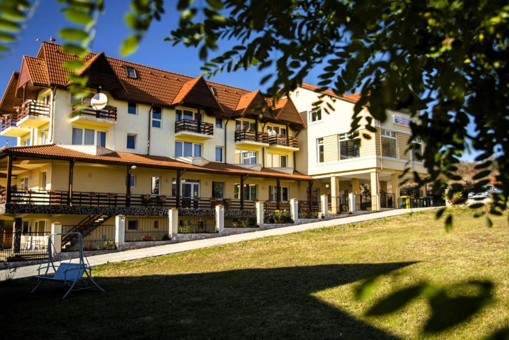 a large white building with a red roof at Pensiunea Carmen - Bikers Friendly Nest in Sibiu