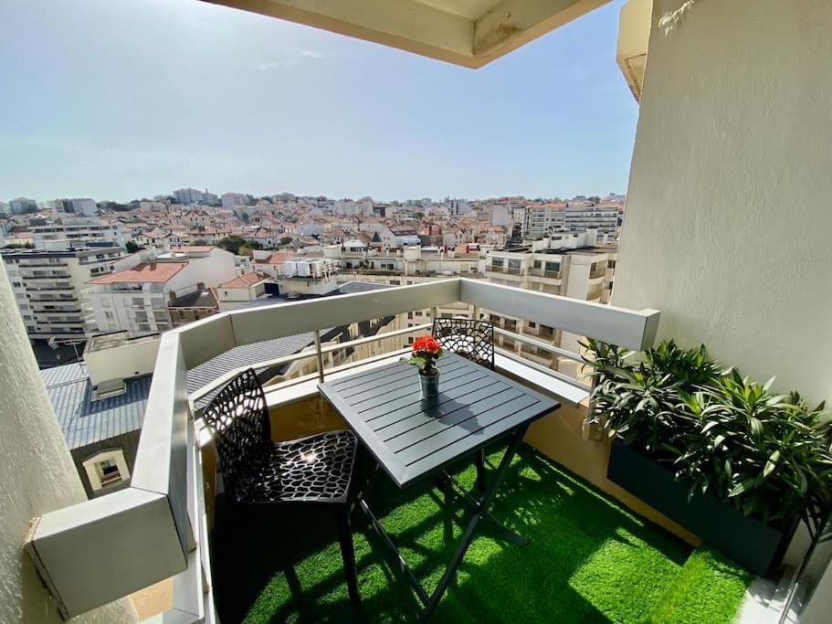 - un balcon avec une table et des fleurs dans l'établissement BIARRITZ GRANDE PLAGE - STUDIO AVEC BALCON - Victoria Surf, à Biarritz
