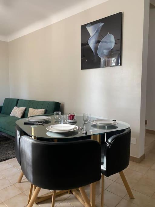 - une table avec des chaises et des assiettes dans le salon dans l'établissement Maison de village, à Fourques