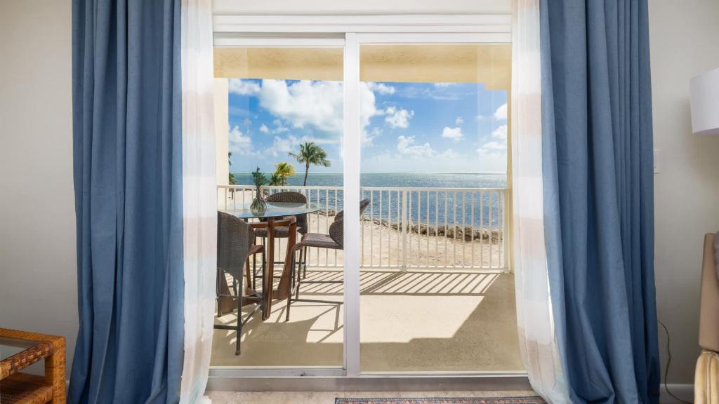 a room with a balcony with a view of the ocean at Whispering Palms Sea Gulls 210 in Key Largo