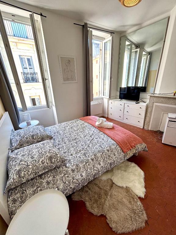une chambre avec un lit et une grande fenêtre dans l'établissement L'escapade marseillaise, à Marseille