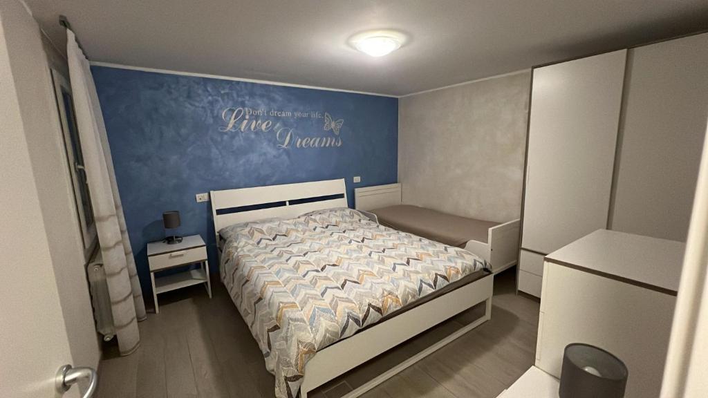 niewielka sypialnia z łóżkiem i niebieską ścianą w obiekcie Dreams 116 Calle Cipolla w mieście Chioggia