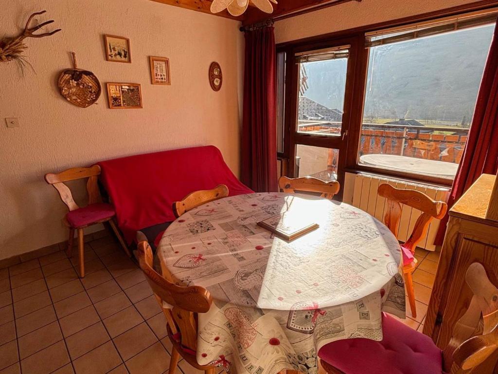 einen Tisch und Stühle in einem Zimmer mit Fenster in der Unterkunft Appartement 2 chambres avec balcon exposé Sud, parking et navettes à proximité - FR-1-692-39 in La Chapelle-dʼAbondance