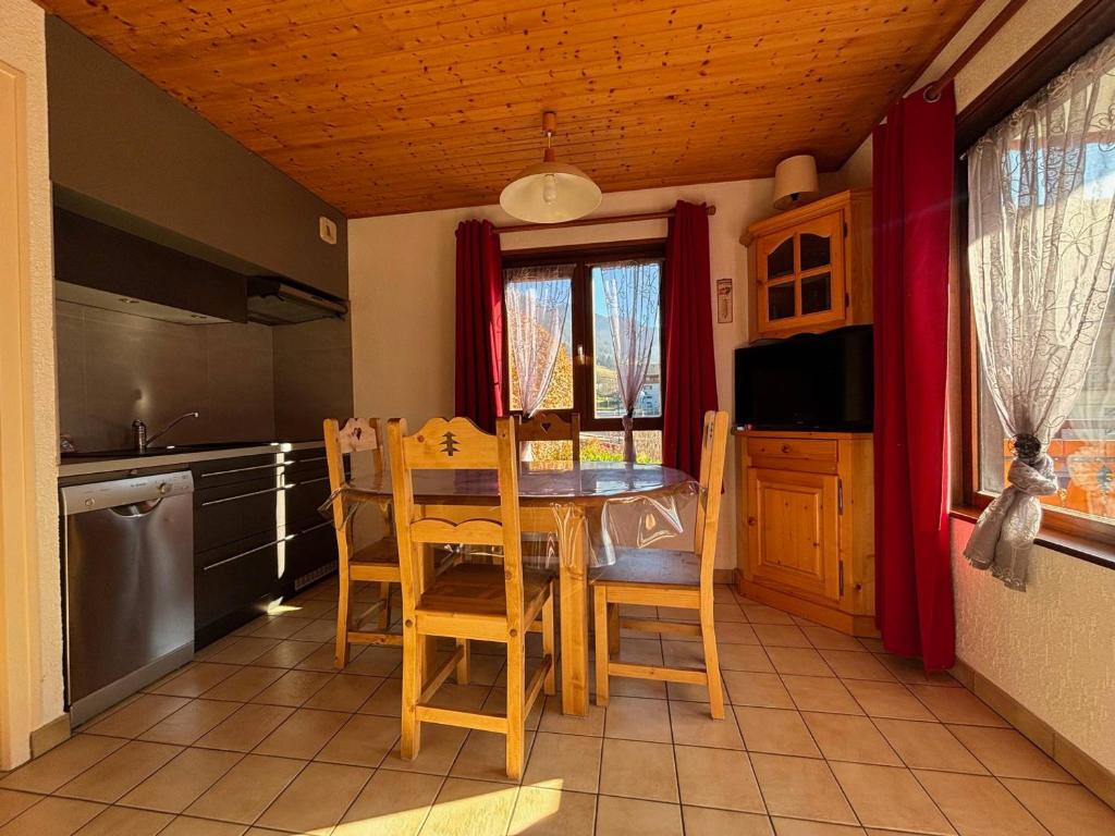 une cuisine avec une table et des chaises dans une pièce dans l'établissement Multi Pass 3€/jour/pers - Charmant 2P au centre du village, 6 pers, balcon sud, parking, non fumeur - FR-1-692-27, à La Chapelle-dʼAbondance