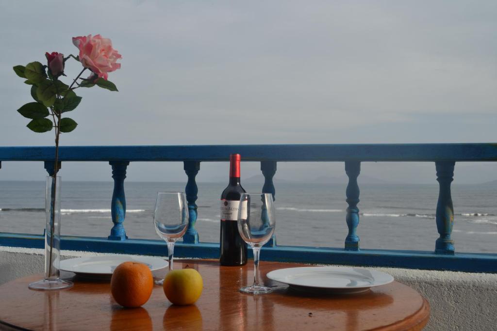 a table with two glasses and a bottle of wine at Absolute Beachfront Apartment in Famara