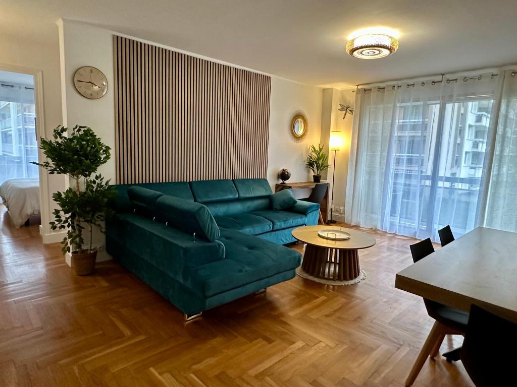 un salon avec un canapé vert et une table dans l'établissement Appartement 5 personnes Léon Frot PARIS, à Paris