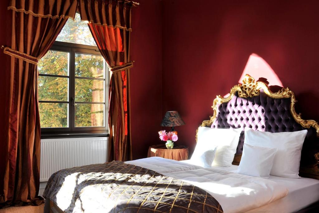 Schlafzimmer mit einem Bett und einem Fenster in der Unterkunft Schlosshotel Marihn in Marihn