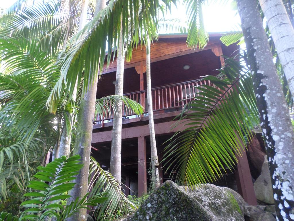 a resort building with palm trees in front of it at Hillside Retreat in Baie Lazare Mahé
