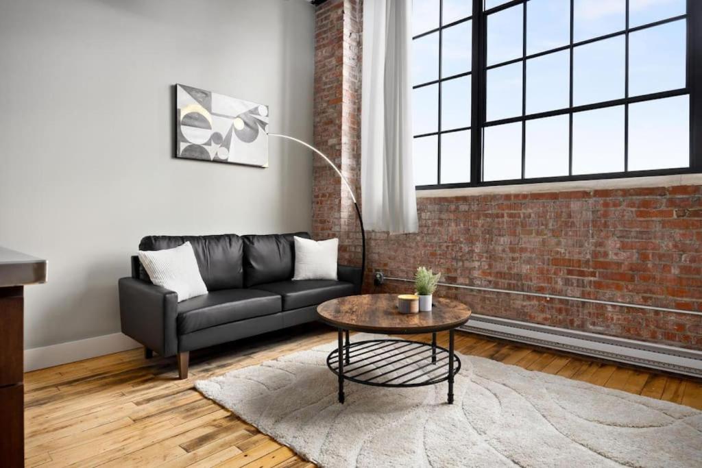 a living room with a couch and a table at Chic Loft in Peoria Warehouse District in Peoria