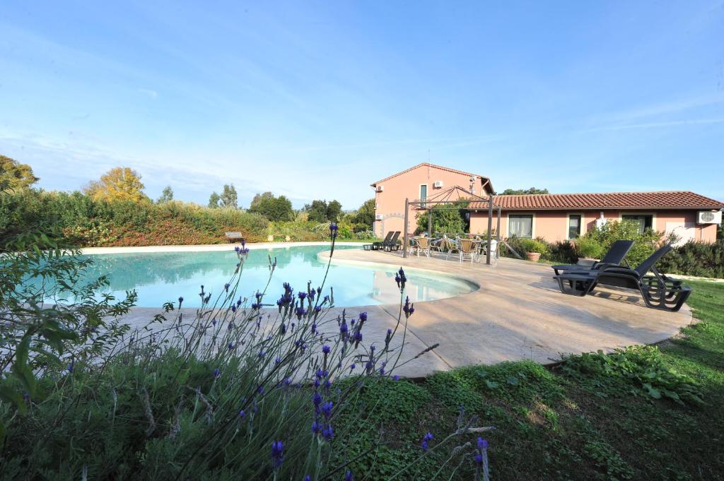 ein Schwimmbad in einem Hof neben einem Haus in der Unterkunft L'Orto in San Vero Milis