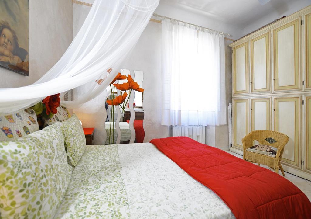 una camera da letto con un letto con una coperta rossa e una finestra di Oasi di pace a Firenze