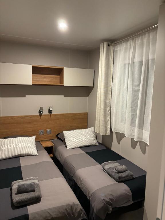 sypialnia z dwoma łóżkami i oknem w obiekcie A Casa Mia Plage w mieście Hermanville-sur-Mer