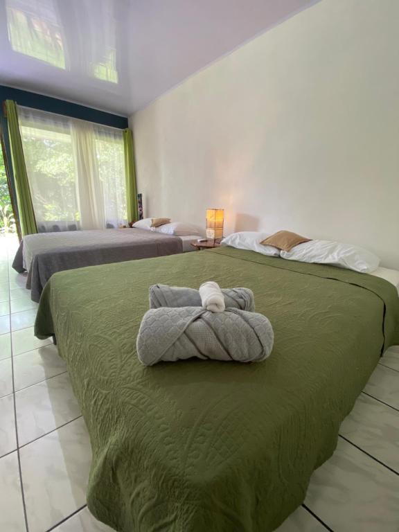 Agua AzulにあるVilla Granja Agua Azul-wi-fi-AC-6 Personas-parqueoのベッドルーム1室(ベッド2台、ベッド上にタオル付)