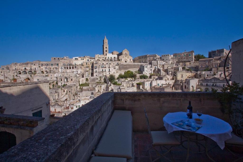 einen Tisch mit einer Flasche Wein auf einem Gebäude in der Unterkunft L'Hotel In Pietra in Matera