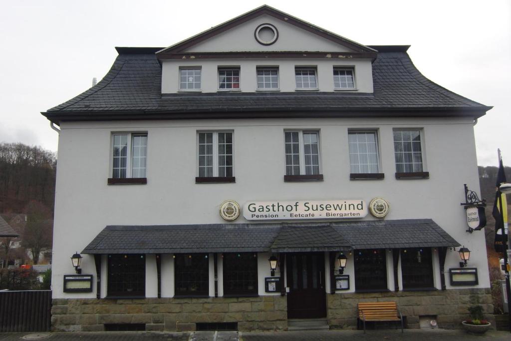 um edifício branco com uma placa na frente dele em Gasthof Susewind em Antfeld
