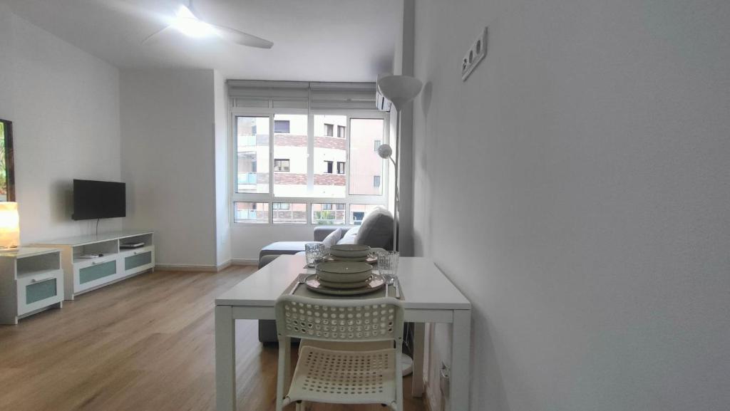 a white living room with a table and a couch at Estudio Pastora in Torremolinos