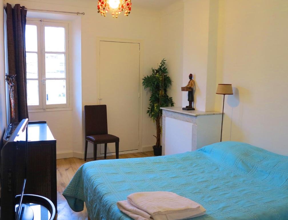 a bedroom with a bed and a chair and a window at Viva Riviera - 10 Rue Commandant André in Cannes