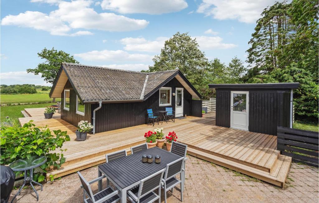 a small cabin with a deck with a table and chairs at Holiday Home Slivsø Haderslev Ii in Haderslev
