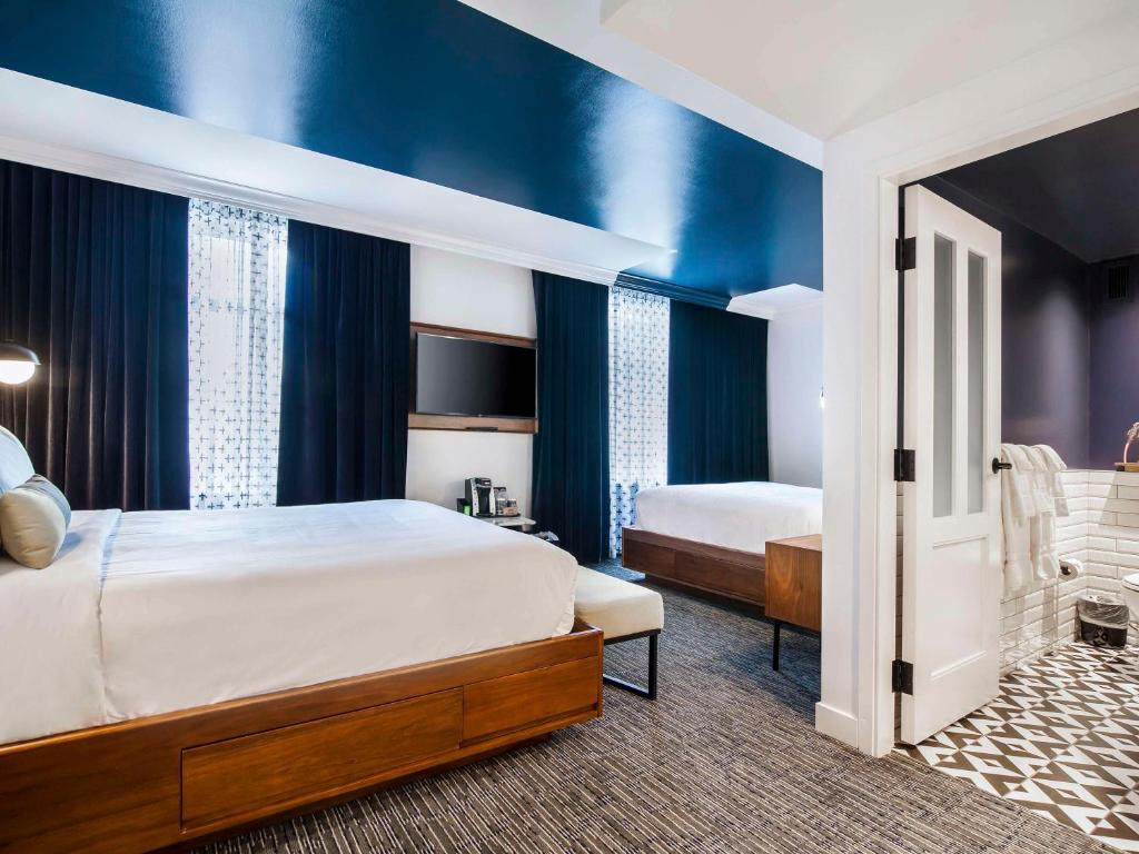 a bedroom with a large bed and blue walls at Hotel Belmont Vancouver - MGallery Collection in Vancouver
