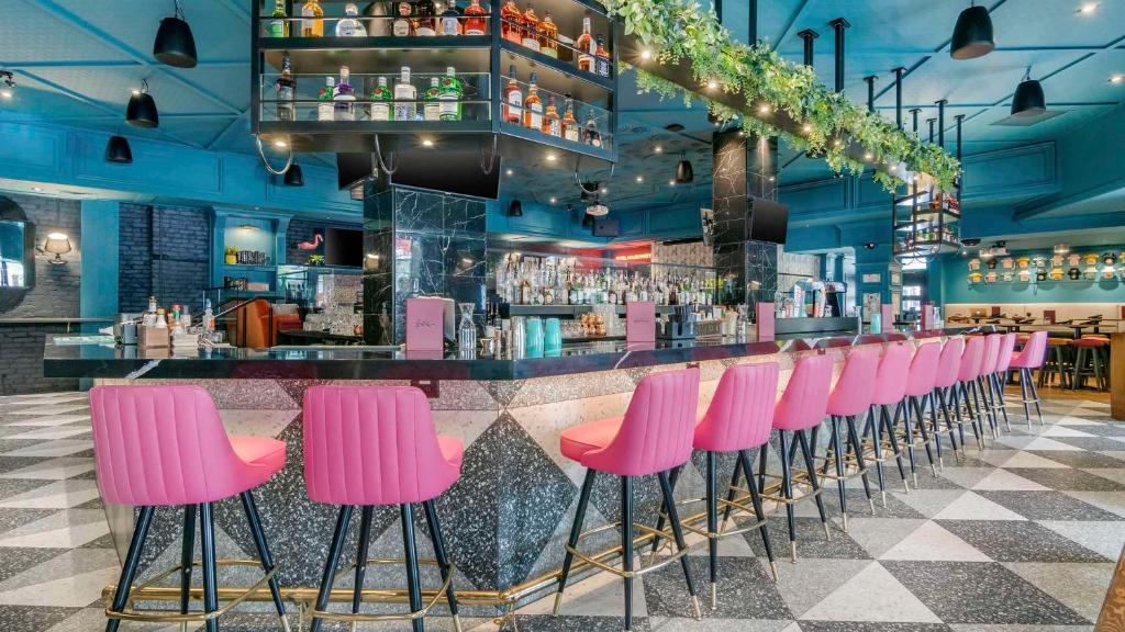 a row of pink stools in a bar at Hotel Belmont Vancouver - MGallery Collection in Vancouver