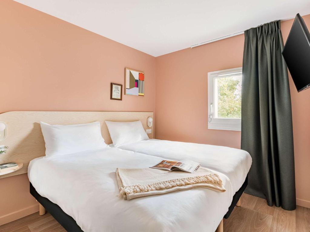 Postel nebo postele na pokoji v ubytování greet Hôtel Prévessin Genève Aéroport