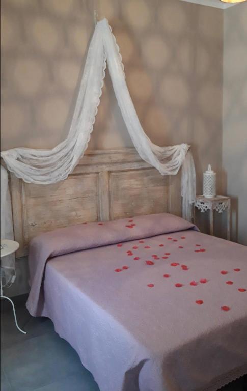 a bed with a canopy with red flowers on it at Dimora Storica Gold Room in Ruviano