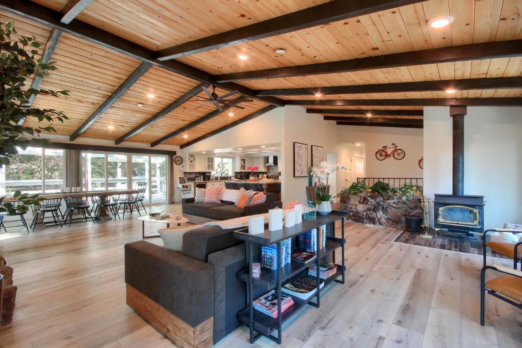 sala de estar con techos de madera y chimenea en Doe Cabin Hot Tub/Playground/Game Room and more!, en Yosemite Forks