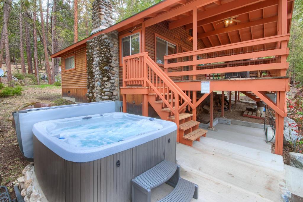 une maison avec un bain à remous sur une terrasse dans l'établissement Acorn Alley Inside Yosemite - Dog Friendly w/Hot tub, Fire pit, EV Charger, à North Wawona