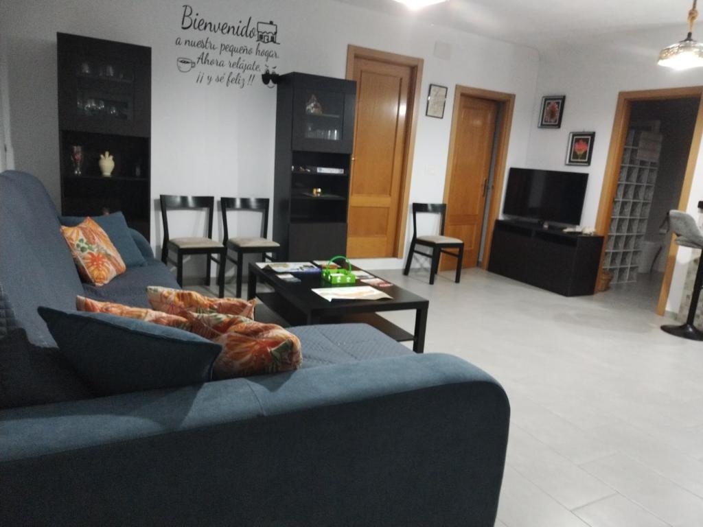 un soggiorno con un divano blu e un tavolo di Casa rural Los Rosales a Lanjarón