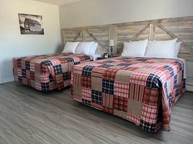 two beds sitting next to each other in a room at Motel Tipton in Tipton