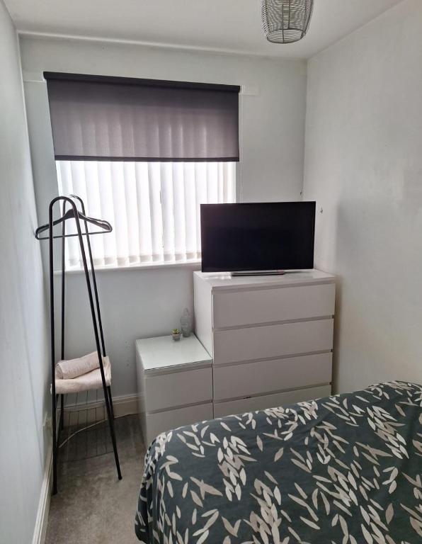 a bedroom with a bed and a dresser with a television at Hertfordshire in Letchworth