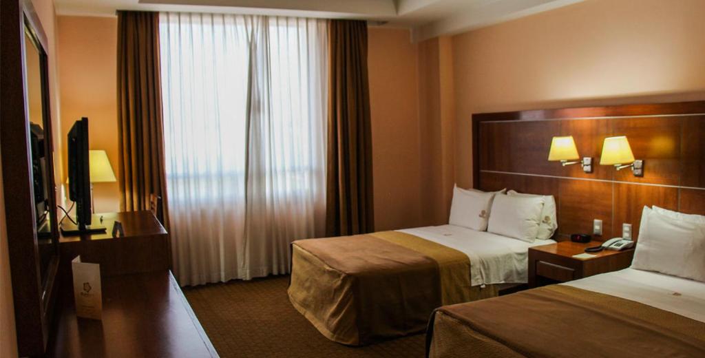 Postel nebo postele na pokoji v ubytování Hotel Soleil Celaya