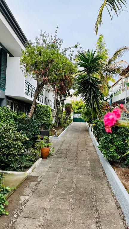a walkway with pink flowers and plants on a building at Monte Verde in Funchal