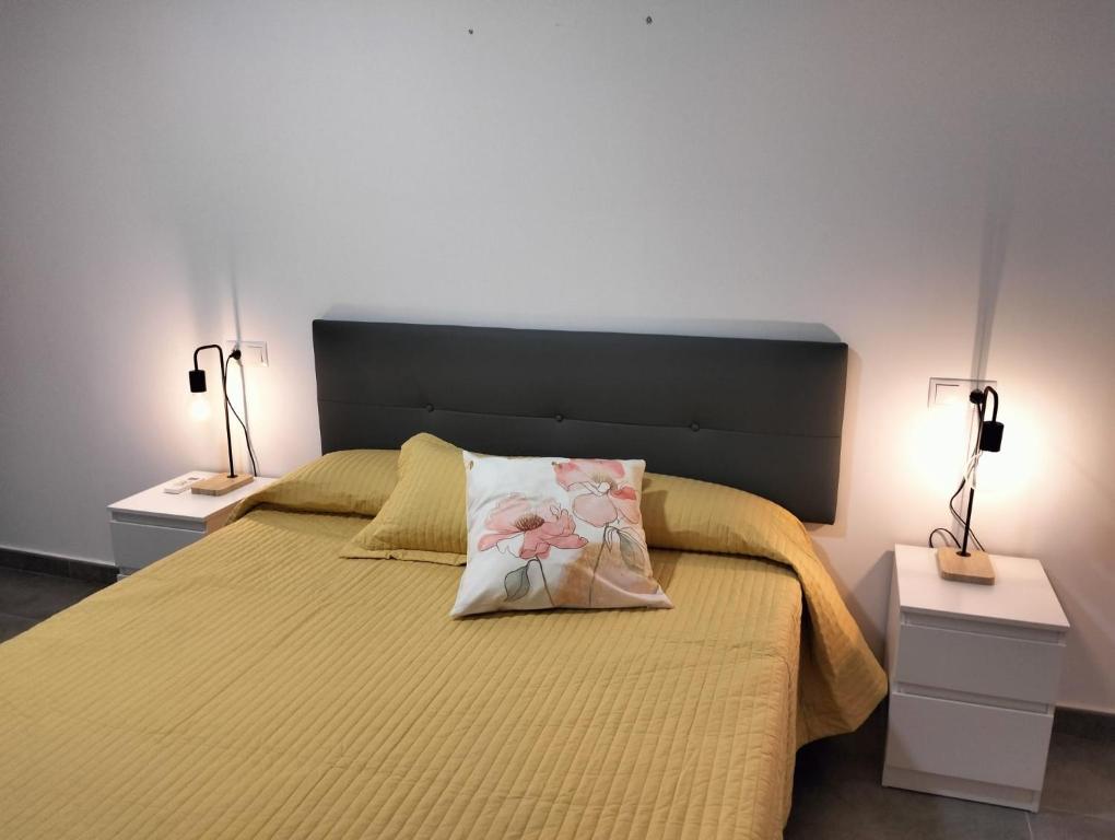 Un dormitorio con una cama grande con dos mesitas de noche. en Alojamiento las Dunas alto, en Tabernas