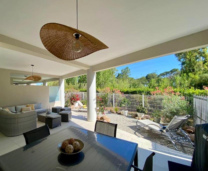 un grand salon avec une table et des chaises dans l'établissement Rez-de-jardin 6 - Accès direct à la plage, à Calvi